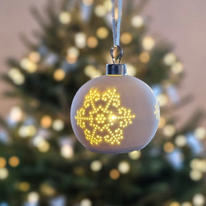 The Lighted Snowflake Ornament Set brings an enchanted winter touch to your home. Features a crisp, white un-glazed ceramic, lending a quiet elegance with an organic, minimalist feel. The snowflake design has a lace-like quality. Each has a flat bottom, so it can easily sit on a shelf or hang from a tree. 