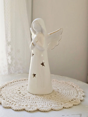 Enhance your home with the serene charm of our Lighted Ceramic Angel. Featuring a simple, organic design, this tabletop piece exudes understated elegance. Its clean white finish remains striking even without the gentle glow of the warm LED light, making it an ideal addition to both classic and modern farmhouse interiors. Requires two LR44 batteries (included). 6.25"H
