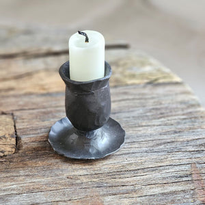 Add rustic ambiance with our Hand-Forged Taper Candle Holder. Featuring a primitive and minimalist design, this black metal holder boasts a hand-forged finish that adds an old-school blacksmith look. Perfect for adding a quiet simplicity to any room. Holds regular size taper candle. Taper candle not included