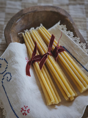 These slim Monastery Beeswax Taper Candles offer a unique touch that will add a sweet charm and the warm scent of honey to any room. These beautiful 1/4" by 8" tapered beeswax candles make a stunning natural element that provide soft bright light as they burn. Come as a set of 10 wrapped in velvet ribbon. Candles burn for 1.5 hours. Perfect to use for meditation or as birthday candles. Set of 10. Ribbon color will vary.