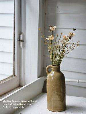 Introduce a touch of Colonial charm to any space with our Mustard Tan Jug with Handle. Crafted from high-quality porcelain and finished with a subtle crackle glaze, this jug is a versatile addition to your decor. Use it as a standalone piece or fill it with flowers for a lovely accent. 4.75" Diam x 11"H