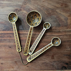 Elevate your culinary rituals with the Mustard Block Print Enameled Measuring Spoon Set, where timeless artisanal design meets everyday functionality. Each spoon features an exquisite block print pattern rendered on a warm mustard tone, complemented by a refined matte gold finish that catches the light with understated elegance.