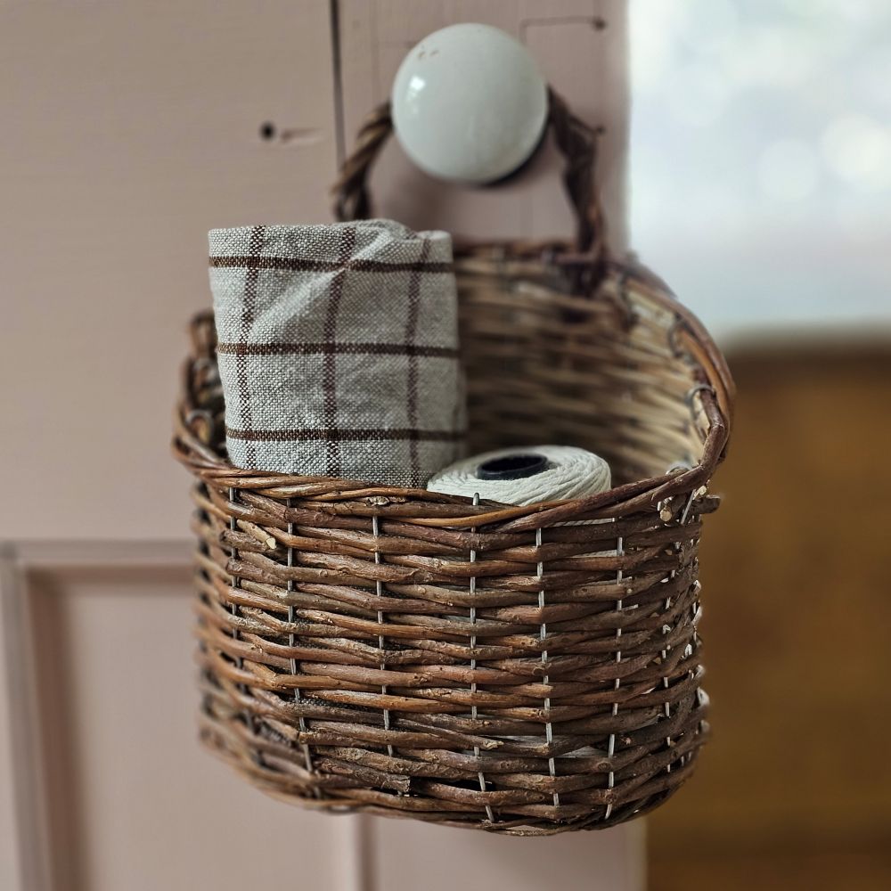 Bring a timeless French country charm to your home with our Natural Willow Wall Basket. Crafted from rich natural willow, this wall basket is built with a classic English cottage feel and makes a unique storage option for farmhouse kitchens. It is perfect for seasonal greens and flowers and adding a vintage-inspired touch to any room. Basket only. Flowers and other items sold separately. 8"L x 10.5"H