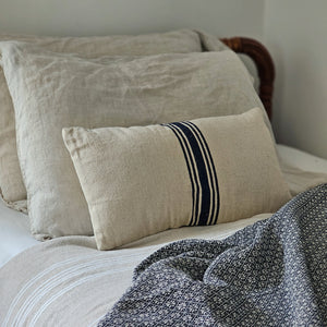 This double-sided accent pillow lends vintage charm to any room. The Grain Sack Oatmeal and Navy Stripe Pillow has the look of well-worn feed sack material. Its warm oatmeal color and dark navy stripes give it French Country farmhouse feel. 100% cotton outer with polyester fiber fill. 18"L x 8"H