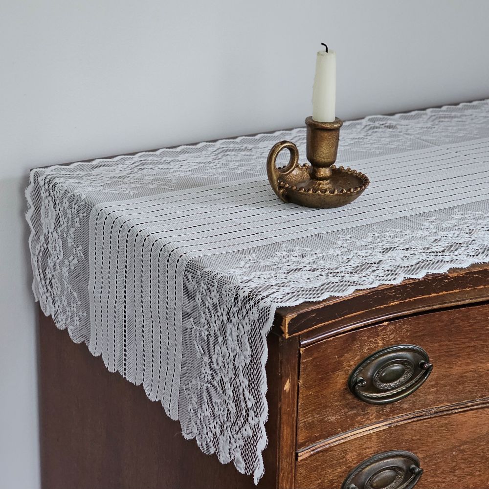 Our Old-World White Lace Table Runner adds a light and breezy touch of elegance to your home. This sheer lace runner has a dreamy quality and creates instant vintage charm that is perfect for country cottage living. Translucent white lace features a floral design inspired by old-world veils and scalloped edging. Blend of cotton, linen and polyester. 17.5”W x 47.24”L
