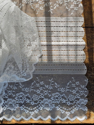 Our Old-World White Lace Table Runner adds a light and breezy touch of elegance to your home. This sheer lace runner has a dreamy quality and creates instant vintage charm that is perfect for country cottage living. Translucent white lace features a floral design inspired by old-world veils and scalloped edging. Blend of cotton, linen and polyester. 17.5”W x 47.24”L