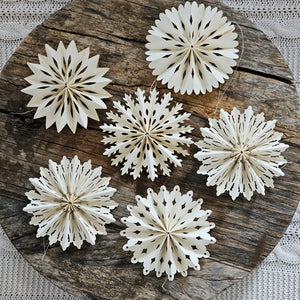 Capture the timeless elegance of winter with these exquisite paper snowflake ornaments. This curated collection of twelve delicate white cutouts evokes cherished seasonal traditions while adding refined charm to any holiday display. Each ornament features a convenient string hanger for effortless arrangement, allowing you to showcase these intricate designs throughout your home with grace and simplicity. Set of 12. Each is 4" in Diam
