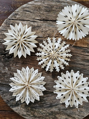 Capture the timeless elegance of winter with these exquisite paper snowflake ornaments. This curated collection of twelve delicate white cutouts evokes cherished seasonal traditions while adding refined charm to any holiday display. Each ornament features a convenient string hanger for effortless arrangement, allowing you to showcase these intricate designs throughout your home with grace and simplicity. Set of 12. Each is 4" in Diam