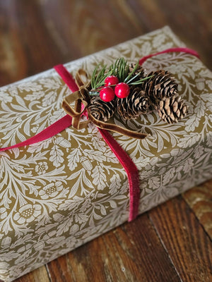 Add a touch of old-fashioned charm to your holiday decor with the Hanging Birchcones and Berries Ornament. Real birchcones beautifully contrast with faux red berries and a pine sprig adorned with a luxurious gold velvet bow. It's the perfect gift topper for a sophisticated and elegant touch. 2.5"W x 3"L