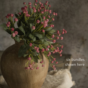 Let the garden spirit fill your farmhouse with this sweet Pink Mini Flower Bundle. This faux floral pick is lush and packed with delicate blossoms, making it an easy choice to fill any basket or vase. It bundle features three stems with small pink blossoms teeming with a natural verve. The forest green leaf accents add a fresh and realistic pop. 