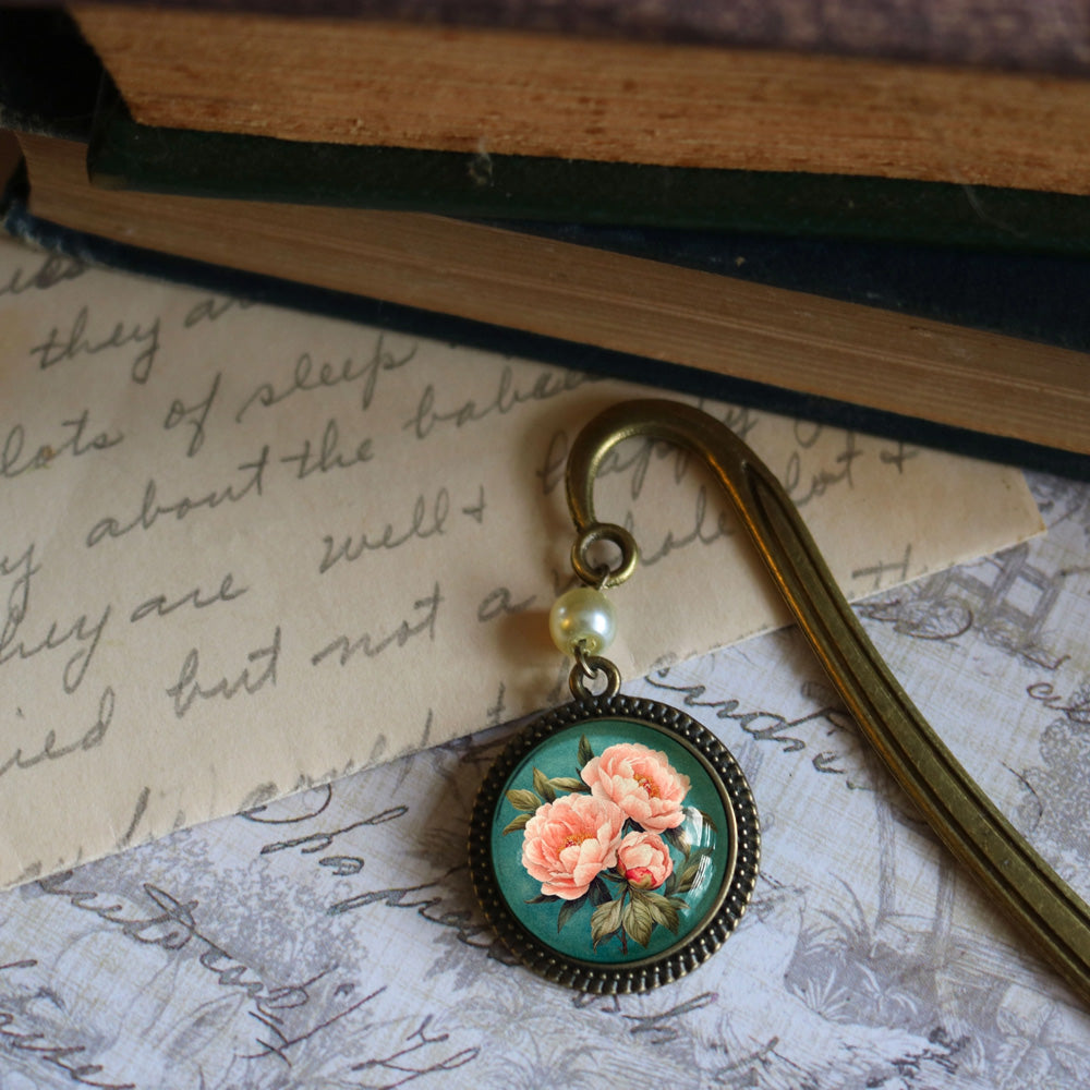 The Peony Book Hook makes a lovely gift for the book lover. Vintage romance is infused in this bookmark that features a glass cabochon and antique bronze hook with a pearl bead accent.