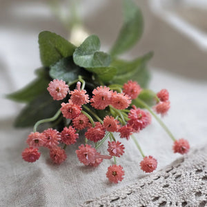 Let the garden spirit fill your farmhouse with this sweet Pink Mini Flower Bundle. This faux floral pick is lush and packed with delicate blossoms, making it an easy choice to fill any basket or vase. It bundle features three stems with small pink blossoms teeming with a natural verve. The forest green leaf accents add a fresh and realistic pop. 