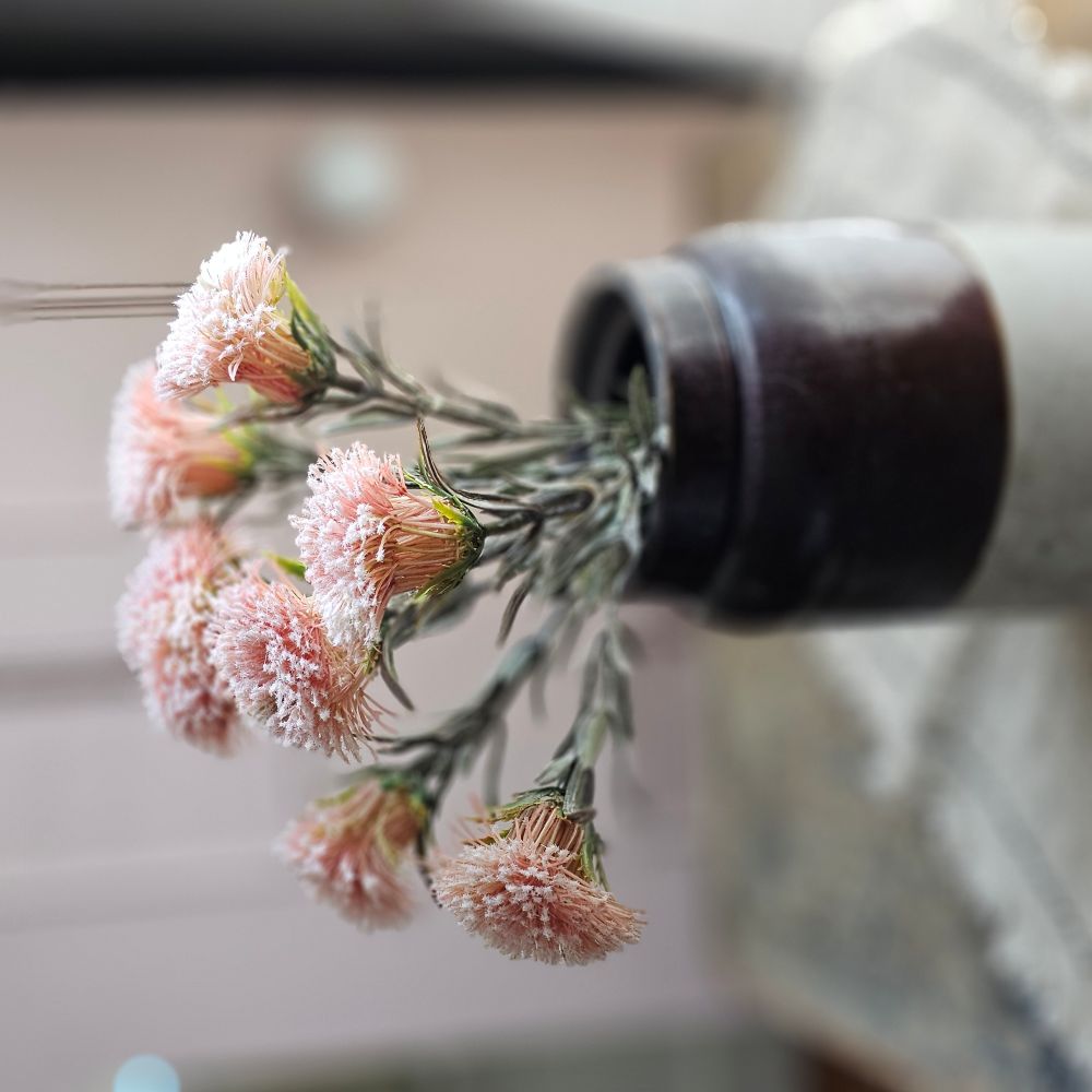 Give your decor a cheerful pop of cottage color with this Pink Thistle Flower Pick. This faux floral is lush and packed with soft pink flowers that replicate the look of this English garden favorite. Each pick contains seven flowers on wire stems, which makes it easy to shape to fit any vase or basket. Each bundle is approximately 14.5”H.