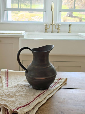 Introduce a touch of old-world elegance with the Pompei Pitcher. Crafted from metal with an aged copper look, this pitcher boasts a beautiful brown hue with hints of copper accenting its surface. Perfect for creating stunning floral arrangements, it makes a lovely addition to any decor. 