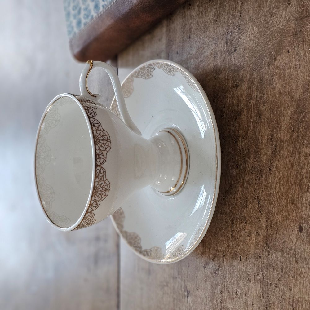 White Porcelain Tea Cup and Saucer with Gold Lace Design