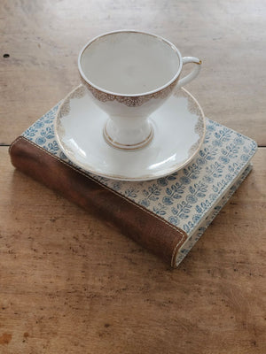 White Porcelain Tea Cup and Saucer with Gold Lace Design