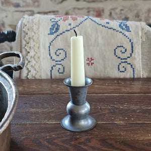 Inspired by old colonial candle holders, our Prentis Pewter Style Taper Candle Holders are crafted with a simple elegance reminiscent of early American farmhouse finds. Made of metal with a distressed pewter-like look. Large measures 5.5" high by 2.5" wide and small is 3"H with a .875" taper cup opening.