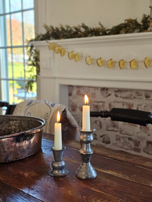 Inspired by old colonial candle holders, our Prentis Pewter Style Taper Candle Holders are crafted with a simple elegance reminiscent of early American farmhouse finds. Made of metal with a distressed pewter-like look. Large measures 5.5" high by 2.5" wide and small is 3"H with a .875" taper cup opening.