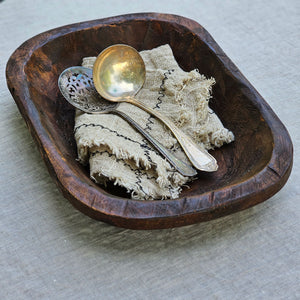 Create a rustic farm table centerpiece with this Primitive Wood Dough Bowl. Inspired by the character of old hand-hewn dough bowls, this rustic piece has a perfectly imperfect look for added charm. The Primitive Wood Dough Bowl decorative bowl is made of thick carved wood. This bowl can be used year-round or displayed seasonally atop a table, shelf, or counter. Each is one-of-a-kind with a dark finish wood that fits perfectly with relaxed rustic style decor.