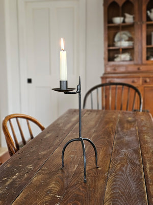 Crafted in the style of an antique reproduction, this candle holder pays homage to our Colonial heritage. Its timeless beauty suits both Early American homes and rustic farmhouses. The tripod style Primitive Wrought Iron Table Taper Candle Holder features an aged finish, protected by a durable lacquer coating to ensure resistance to scratches and rust, guaranteeing lasting appeal.