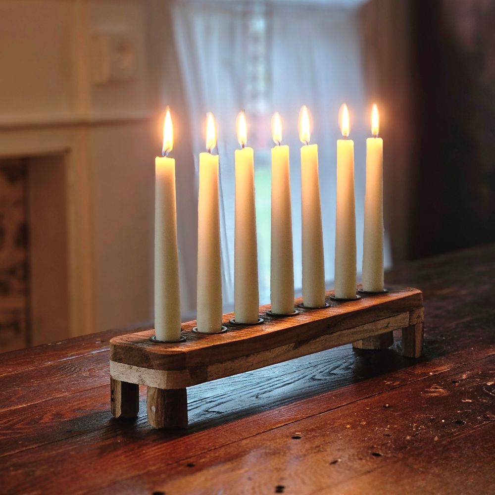 Create a warm, inviting glow with our Reclaimed Wood Taper Candle Centerpiece. Handcrafted from reclaimed vintage wood (finish and grain will vary), this rustic piece features a charming weathered finish and holds seven taper candles for stunning illumination. Perfect for dining tables, mantels, or holiday displays, it brings timeless farmhouse elegance and cozy ambiance to any room or celebration.