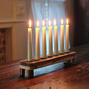 Create a warm, inviting glow with our Reclaimed Wood Taper Candle Centerpiece. Handcrafted from reclaimed vintage wood (finish and grain will vary), this rustic piece features a charming weathered finish and holds seven taper candles for stunning illumination. Perfect for dining tables, mantels, or holiday displays, it brings timeless farmhouse elegance and cozy ambiance to any room or celebration.