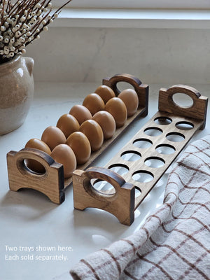 Inspired by antique egg holders, such as ones spotted in the Downton Abbey kitchen, our farmhouse Rustic Wood Stackable Egg Tray will be right at home in your kitchen. It is sold as one tray, and a purchase of two gives you that old-timey stackable look. Makes a great accent for any shelf or countertop. Each rustic wood egg crate holds 12 eggs. Eggs not included. Includes one tray. Purchase two or more for stacking. Made in the USA.