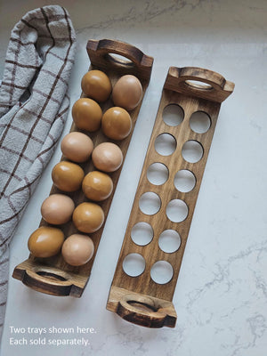 Inspired by antique egg holders, such as ones spotted in the Downton Abbey kitchen, our farmhouse Rustic Wood Stackable Egg Tray will be right at home in your kitchen. It is sold as one tray, and a purchase of two gives you that old-timey stackable look. Makes a great accent for any shelf or countertop. Each rustic wood egg crate holds 12 eggs. Eggs not included. Includes one tray. Purchase two or more for stacking. Made in the USA.