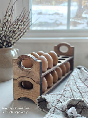 Inspired by antique egg holders, such as ones spotted in the Downton Abbey kitchen, our farmhouse Rustic Wood Stackable Egg Tray will be right at home in your kitchen. It is sold as one tray, and a purchase of two gives you that old-timey stackable look. Makes a great accent for any shelf or countertop. Each rustic wood egg crate holds 12 eggs. Eggs not included. Includes one tray. Purchase two or more for stacking. Made in the USA.