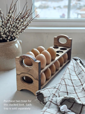 Inspired by antique egg holders, such as ones spotted in the Downton Abbey kitchen, our farmhouse Rustic Wood Stackable Egg Tray will be right at home in your kitchen. It is sold as one tray, and a purchase of two gives you that old-timey stackable look. Makes a great accent for any shelf or countertop. Each rustic wood egg crate holds 12 eggs. Eggs not included. Includes one tray. Purchase two or more for stacking. Made in the USA.