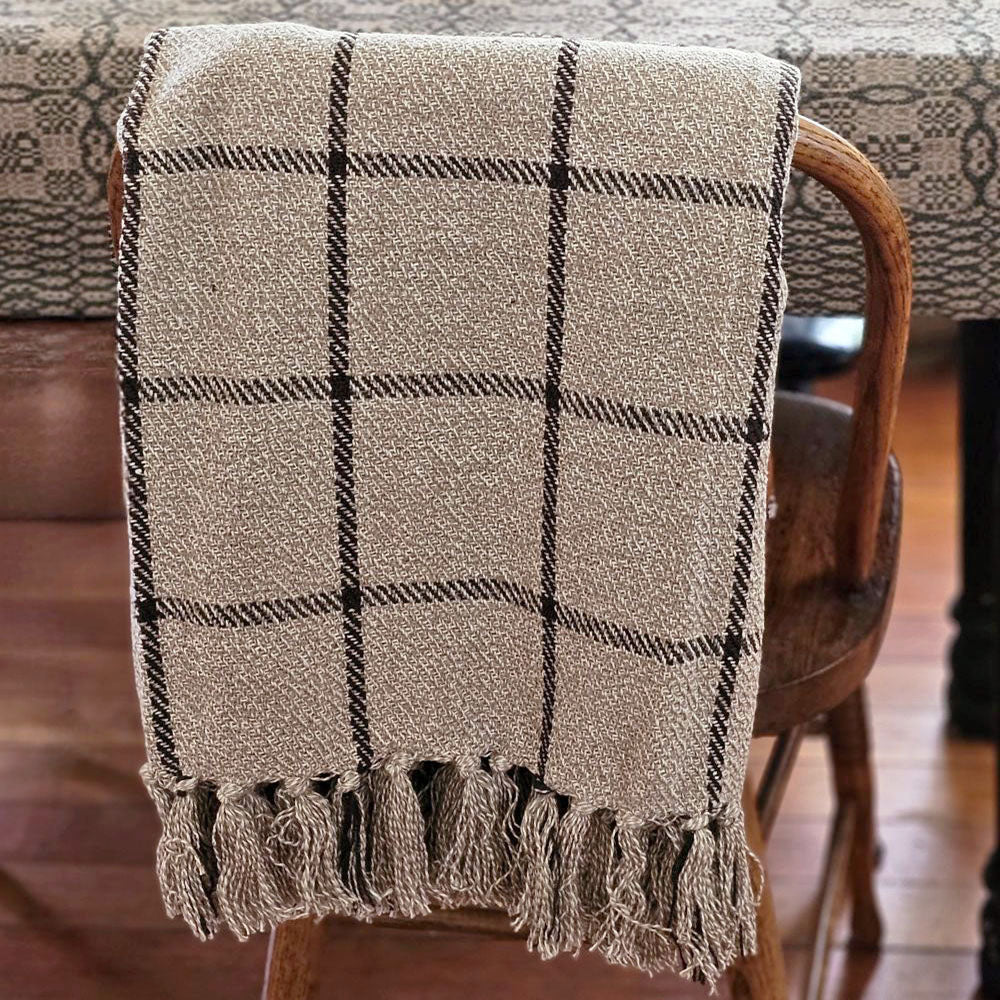 Get cozy and transform your favorite space with the refined style and complete comfort of this Rustic Black Windowpane Throw Blanket. This woven cotton throw features a black grid design on a rustic beige weave with tassels on top and bottom. This soft throw is perfect for creating a cozy home no matter the season. Crafted of 100% cotton, finished with a tassel edges, this throw is machine washable for easy care. 50"W x 60"H
