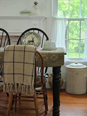 Get cozy and transform your favorite space with the refined style and complete comfort of this Rustic Black Windowpane Throw Blanket. This woven cotton throw features a black grid design on a rustic beige weave with tassels on top and bottom. This soft throw is perfect for creating a cozy home no matter the season. Crafted of 100% cotton, finished with a tassel edges, this throw is machine washable for easy care. 50"W x 60"H