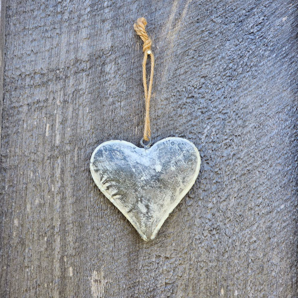 This Rustic Weathered Metal Heart Ornament adds instant farmhouse style charm. Features a gray-washed puffed metal heart ornament with a weathered, distressed finish. Item includes a jute cord hanger.