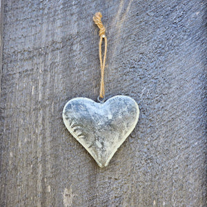 This Rustic Weathered Metal Heart Ornament adds instant farmhouse style charm. Features a gray-washed puffed metal heart ornament with a weathered, distressed finish. Item includes a jute cord hanger.