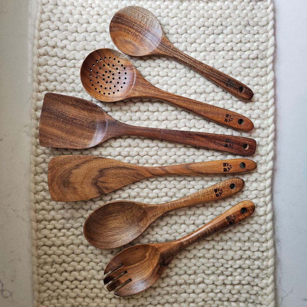 Stir up a little farmhouse style by adding a natural touch to your utensil set. Our Rustic Wood Cooking Utensils make sturdy, sustainable kitchen tools that will last a lifetime with proper care—very farmhouse. Made from premium teak wood, these utensils are durable, smooth, and gentle on cookware. The six-piece utensil set includes a salad spoon, salad fork, serving spoon, skimmer, spatula, and turner. Set of six.