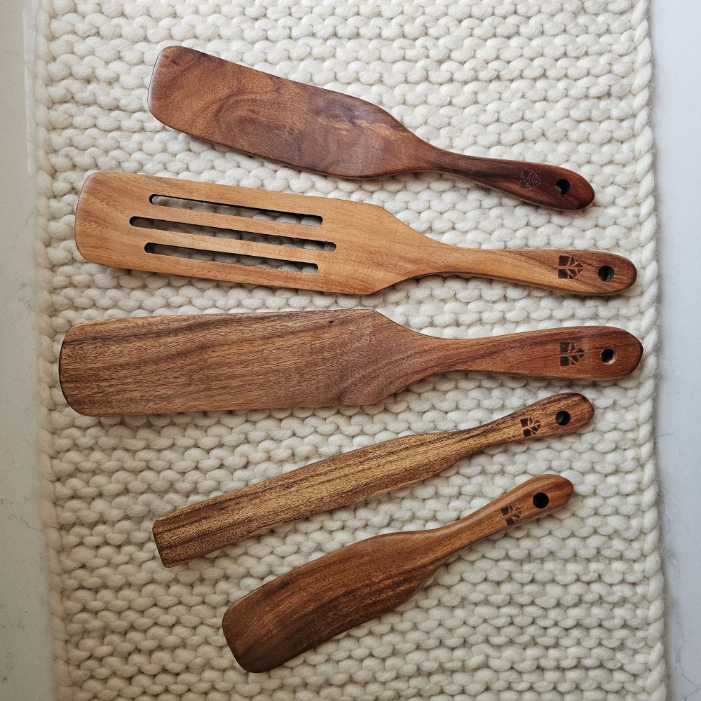 Our Rustic Wood Spurtle Spatula Set includes five durable teak wood utensils, designed for stirring, mixing, scraping, and serving. With their unique shape, these spurtles glide smoothly along cookware, making them ideal for everything from folding batter to sautéing. Lightweight yet sturdy, they offer a comfortable grip and are gentle on non-stick surfaces. A natural, eco-friendly alternative to plastic, this set brings both practicality and timeless style to any kitchen. Set of five.