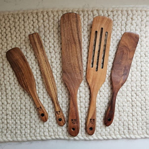 Our Rustic Wood Spurtle Spatula Set includes five durable teak wood utensils, designed for stirring, mixing, scraping, and serving. With their unique shape, these spurtles glide smoothly along cookware, making them ideal for everything from folding batter to sautéing. Lightweight yet sturdy, they offer a comfortable grip and are gentle on non-stick surfaces. A natural, eco-friendly alternative to plastic, this set brings both practicality and timeless style to any kitchen. Set of five.