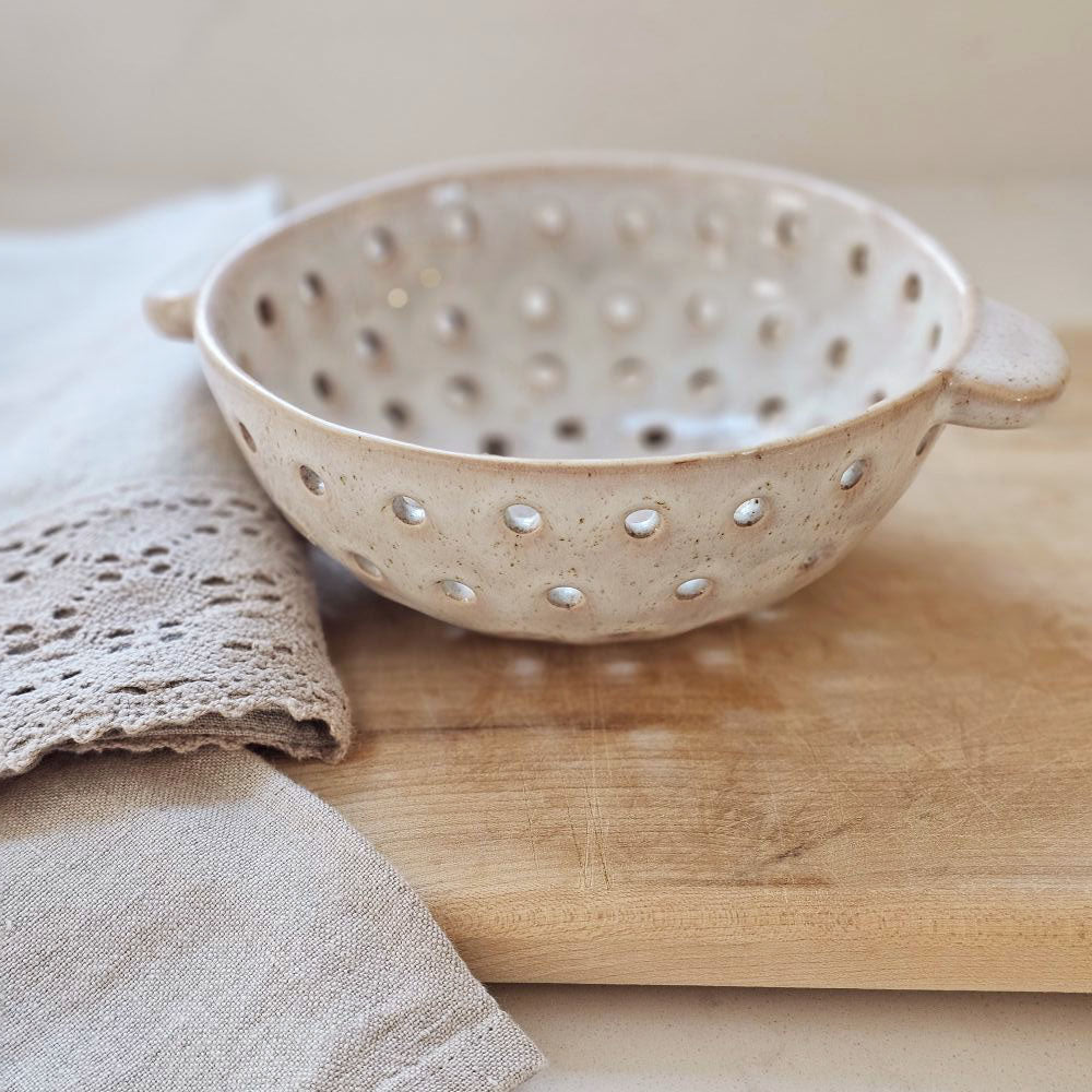 The Rustic Ceramic Colander Berry Bowl offers relaxed farmhouse style. It's perfect for washing berries and fruit or use it to hold sponges and soap. This oatmeal finish has a rustic appearance.