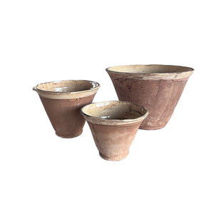 Since the time of the Ancient Greeks, handmade pottery has been a hallmark in southern European farmhouses and beyond. Travel through the Mediterranean regions, and there is no doubt that you will find a bevy of clay dishware. Retaining the rustic, handmade appeal of daily wares, these Rustic Farmhouse Clay Bowls, in three sizes, have a deep, conical shaped basin. The exterior remains a natural clay while the interior and upper lip of the bowl is glazed with a crackled, imperfect buttercream. Set of three