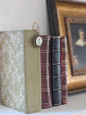 The Scottish Thistle Book Hook makes a lovely gift for the book lover. Celebrate Scottish pride with this bookmark that features a glass cabochon and antique bronze hook. It is just the right size for a perfect stocking stuffer.

Book hooks work by sliding the long metal shaft down between the pages of your book like a traditional bookmark, allowing the accent to dangle along the spine.