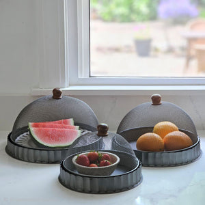 Keep bugs at bay on warm summer days with our Screen Food Covers with Metal Base, Set of Three . A wire mesh cloche, also known as a shoo-fly, is perfect for protecting food from flies and other insects. Our set of three Wire Mesh Food Covers has tons of vintage charm and offers a range of sizes. They feature aged metal base with scalloped edges. Add rustic elegance to your farmhouse kitchen or patio with our vintage style Screen Food Cover Cloches