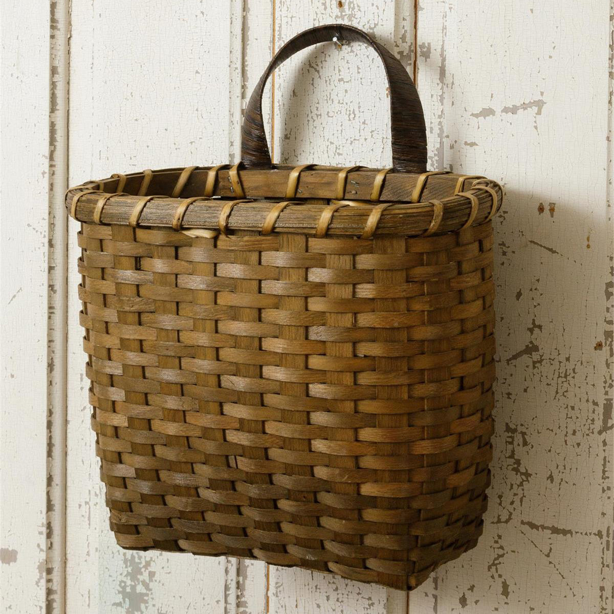The Shaker Style Wall Basket is a woven chipwood basket with a deep brown finish. Add instant farmhouse charm with this large wall basket. It is perfect for displaying winter greens, summer florals, mail, and decorative fillers. Measures 12.50"L x 7.75"deep x 15"H.