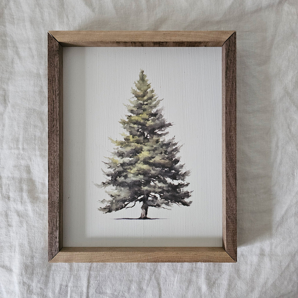Our Simple Evergreen with Wood Frame is handcrafted in the USA. This serene and majestic evergreen tree offers an easy way to add instant charm to any wall or shelf within the home. It is made from high quality American hardwood planks with a hand painted face, and printed with UV cured ink, and is framed in a natural walnut wood frame. Each piece is unique with its own personality, marks, wood grain, and look. Easy to clean with a dry cloth. Made in the USA. 8.75"L x 1.5"W x 10.75"H
