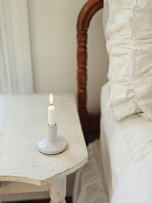 This Simple White Taper Candle Holder, with its quiet elegance and clean design, adds instant ambience to any room. This ceramic taper holder is equal parts modern simplicity and organic imperfection. Features a white glaze finish. Fits smaller taper size with .75" base. 3" diam x 3"H