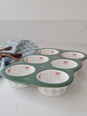 Whether you're baking up something sweet or savory, this Stoneware Muffin Pan with Cottage Style is sure to elevate any recipe. The floral print baking dish holds six muffins or cupcakes. It features a dark sage green base with sweet pink cottage flower graphics in each muffin cup. Dishwasher safe. 12"L x 7.5"W x 1.5"H