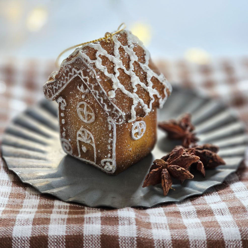 Sugar and spice, everything nice! Our Gingerbread House Ornament looks good enough to eat. Made of resin, this little gingerbread cottage ornament is topped with sugary glitter and a festive white icing design. Looks adorable on a shelf, tree, as or a gift topper.