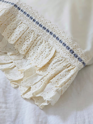 Our Eyelet Ruffles with Velvet Ribbon Pillowcase, Set of Two lends dreamy cottage style to any bedroom. These cream pillowcases feature a double layer of ruffle edges with exquisite floral eyelet detail with a grey blue velvet ribbon woven through a crochet border. This lace edge pillowcase will add texture and a charming vintage look to your room.
