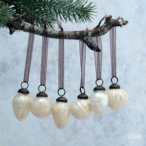 Our Vintage Crackle Glass Bulb Ornaments Mixed Designs come as a set of six different designs. These small hand-blown glass ornaments are inspired by vintage mercury glass bulbs. The glass bauble has a crackle glaze that is applied to the exterior when initially blown. This gives the glass an aged, crackled look. Each bulb is topped with an ornately detailed bronzed colored cap and finished with an organza ribbon for hanging.