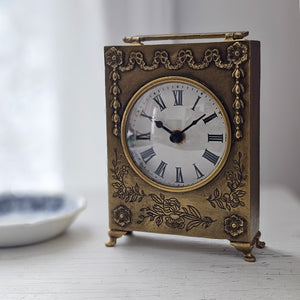 Inspired by flea market finds, the Vintage Gold Floral Embossed Clock features an aged patina and an elegant embossed floral design and etchings. Reminiscent of 18th century style, this charming clock adds an antique look to any desk or side table. Requires 1 AA battery (not included). 4.5"W x1.5"D x7.5"H