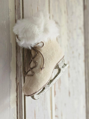 This Vintage Ice Skate Ornament brings a festive touch to any holiday decor. Its old-timey design features a silver sparkle skate, beige fur, and a fluffy white fur collar. Show off your winter wonderland style with this unique ornament for your tree, wreaths, or use as a gift-topper. L: 6.50" W: 2.75" H: 7"  
